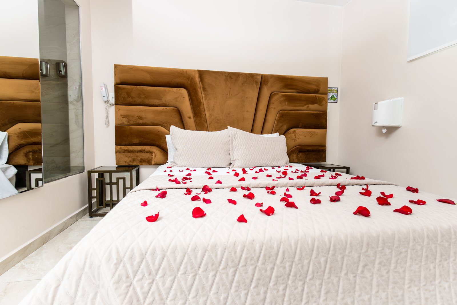 Cama del Hotel Danubio con pétalos de rosa formando un corazón