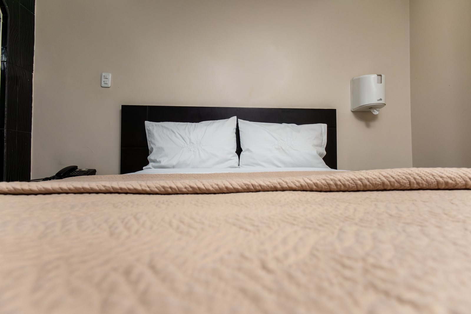 Habitación estándar del Hotel Danubio con cubrecama beige y almohadas blancas