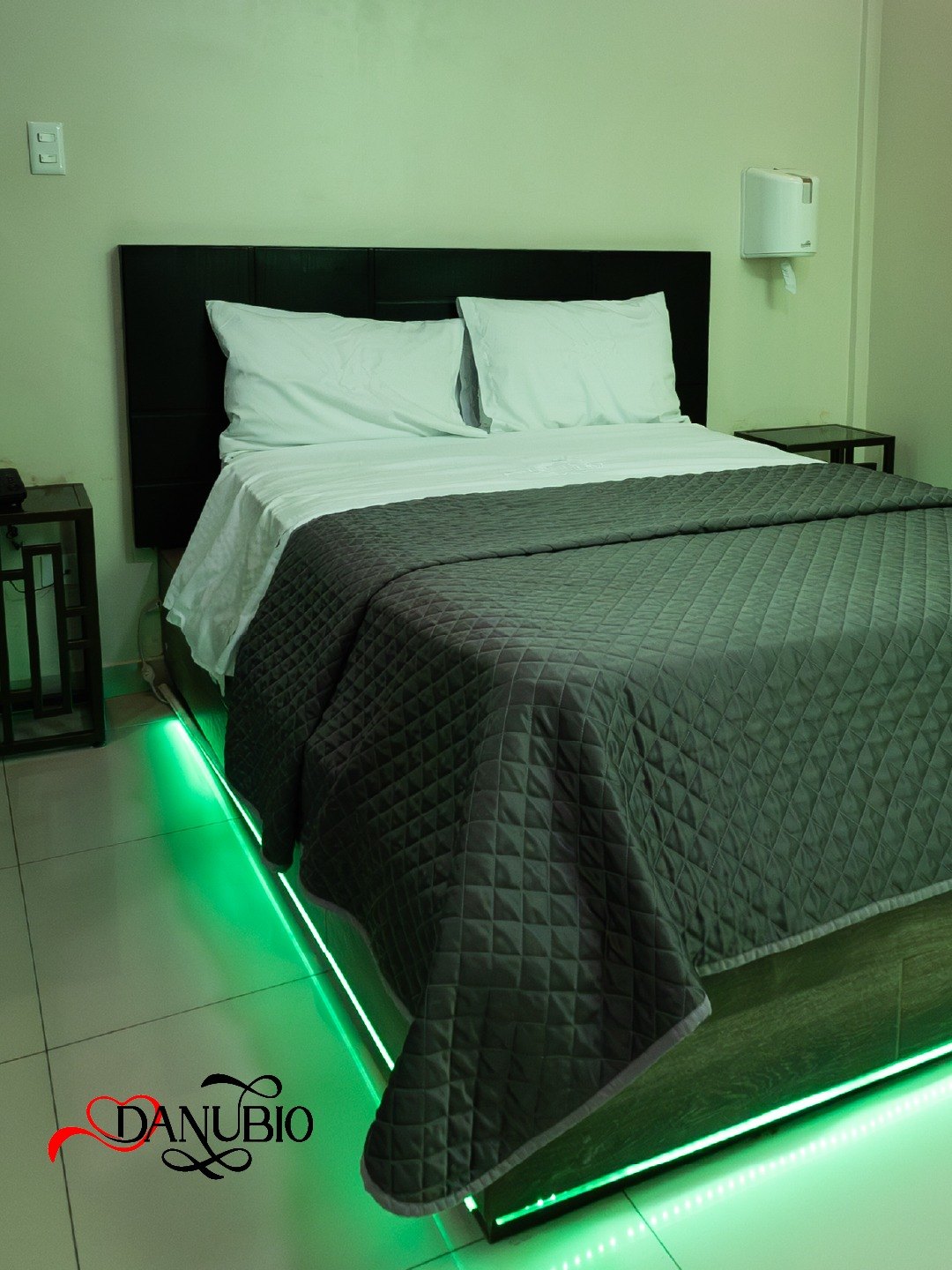 Habitación del Hotel Danubio con cubrecama gris e iluminación LED