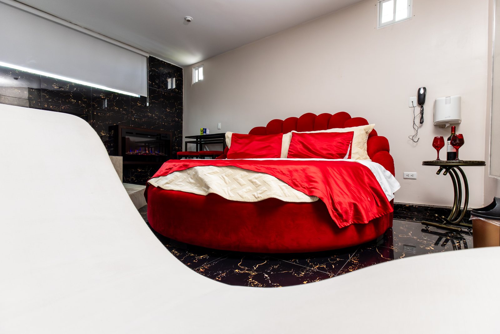 Suite ejecutiva del Hotel Danubio con cama redonda de lencería roja