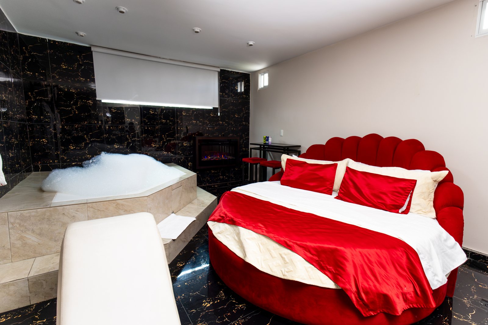 Suite del Hotel Danubio con jacuzzi privado, cama redonda y paredes de mármol negro